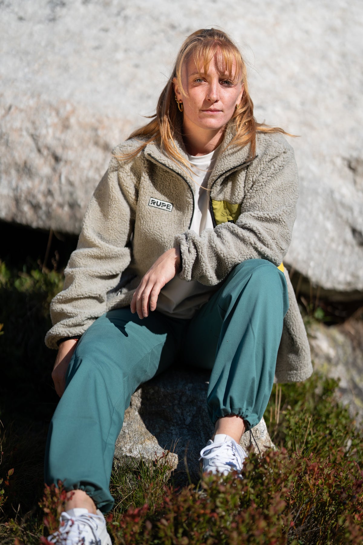 FW26-125 Yeti 2.0 Sunny + Ande Forest Green (donna seduta sul masso)