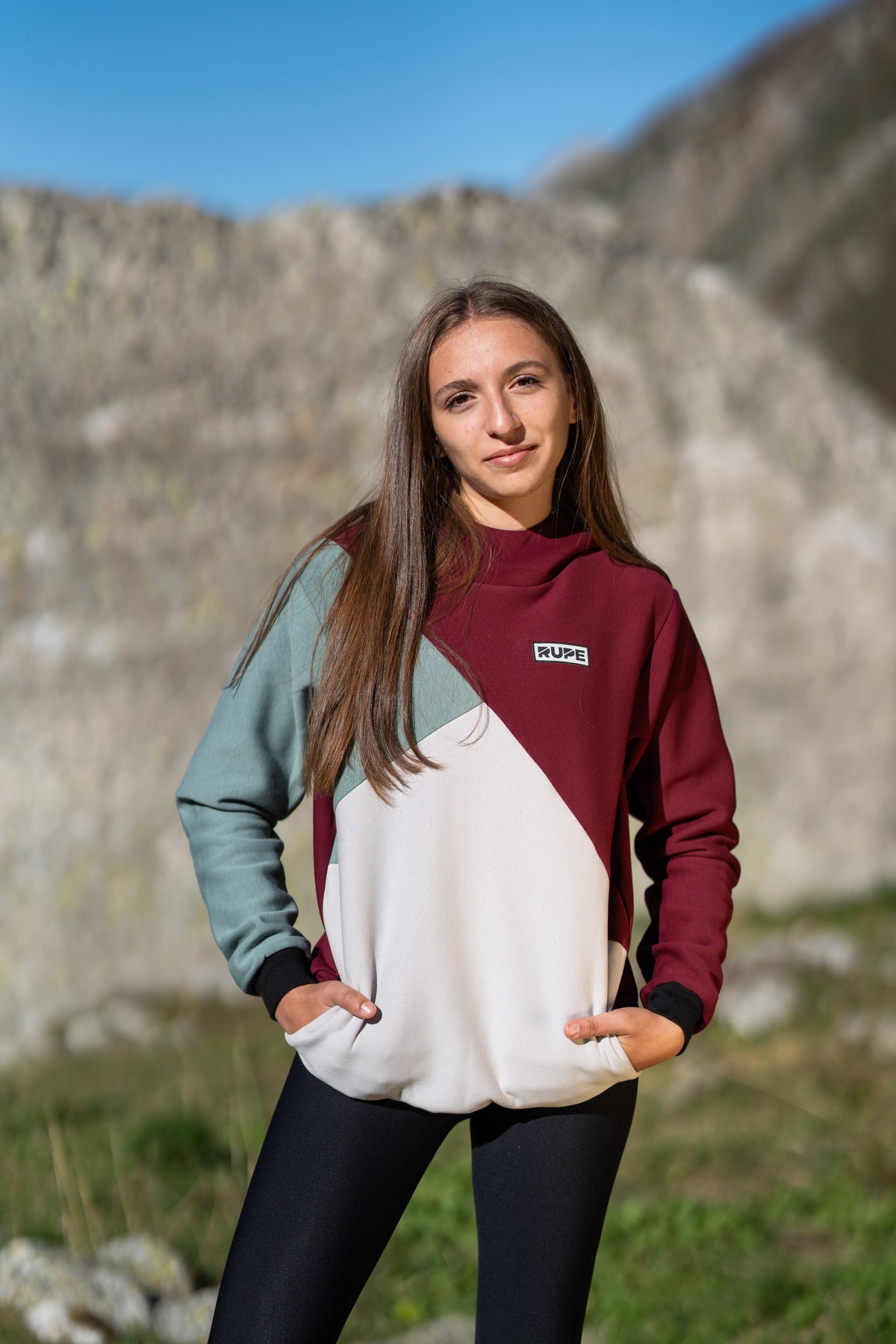 FW26-102 DIHEDRAL Plum + leggings neri (donna frontale, sfondo montagna)