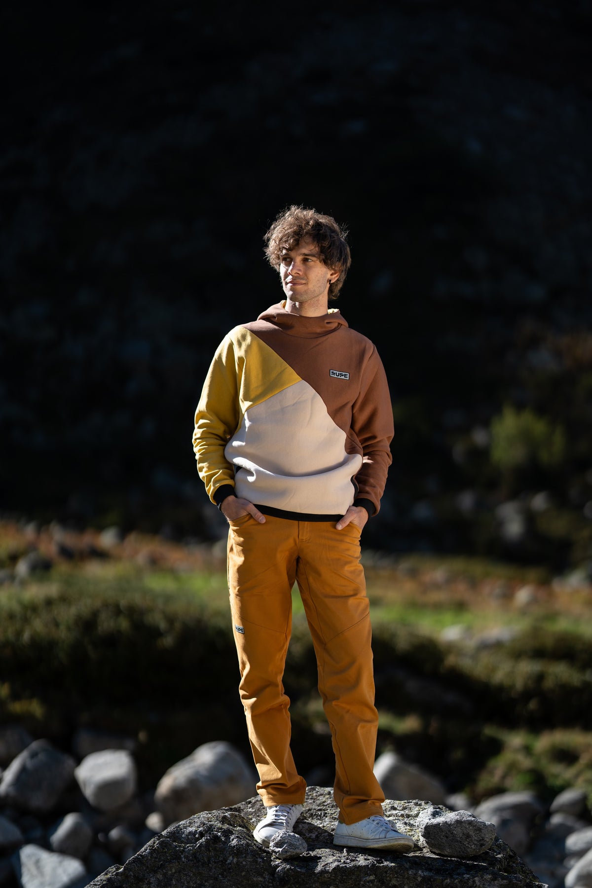 FW26-088 DIHEDRAL Elm + Pirenei Ocra (uomo sul masso, luce serale)