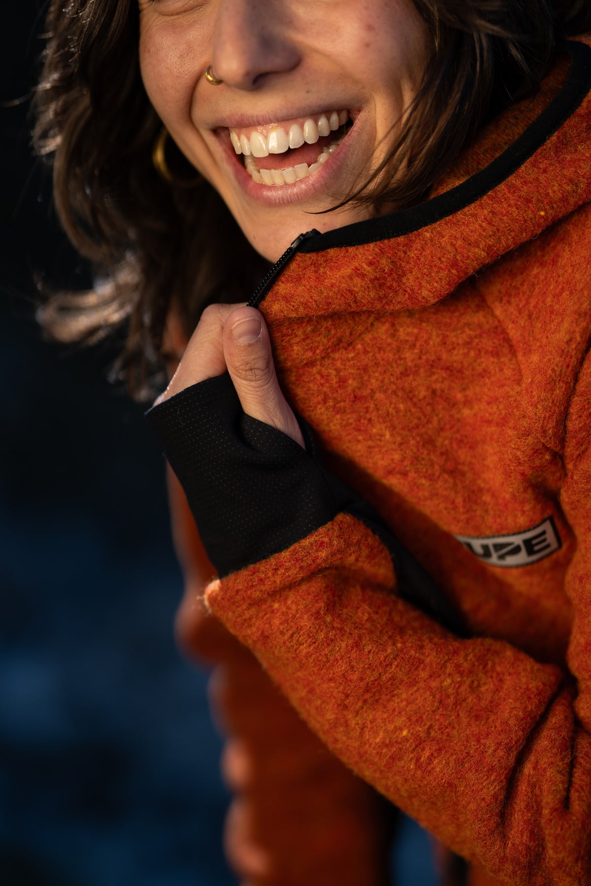 FW26-110 Peak Copper (primo piano risata, dettaglio collo e logo)